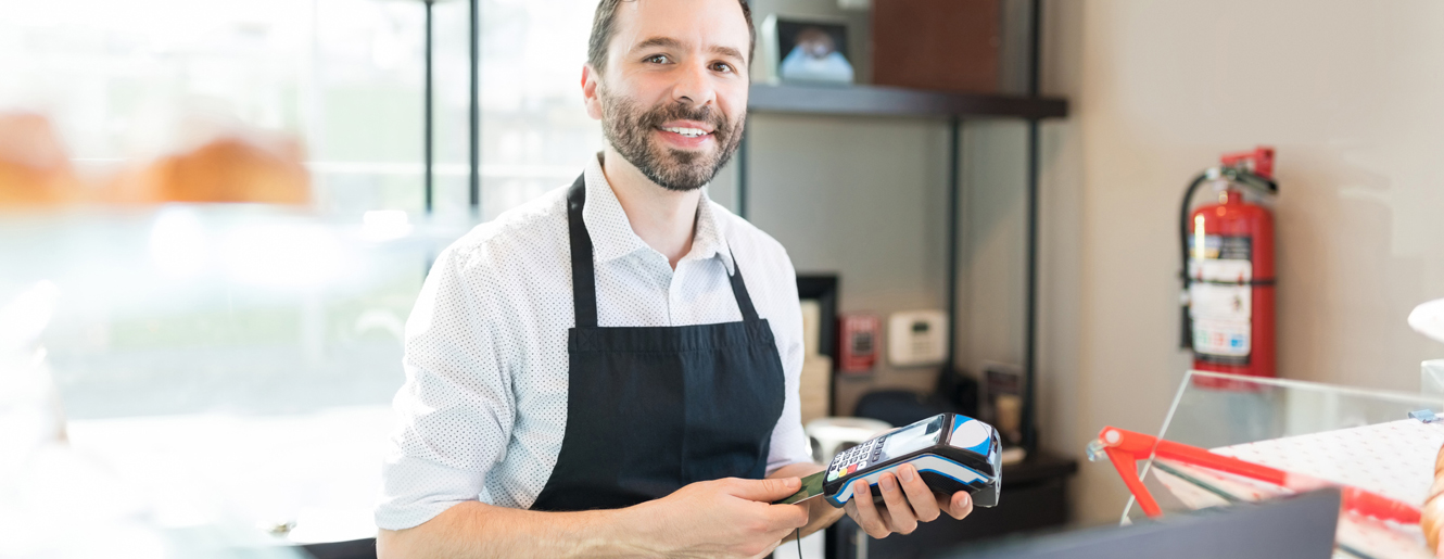 Business owner inserting credit card into card reader.